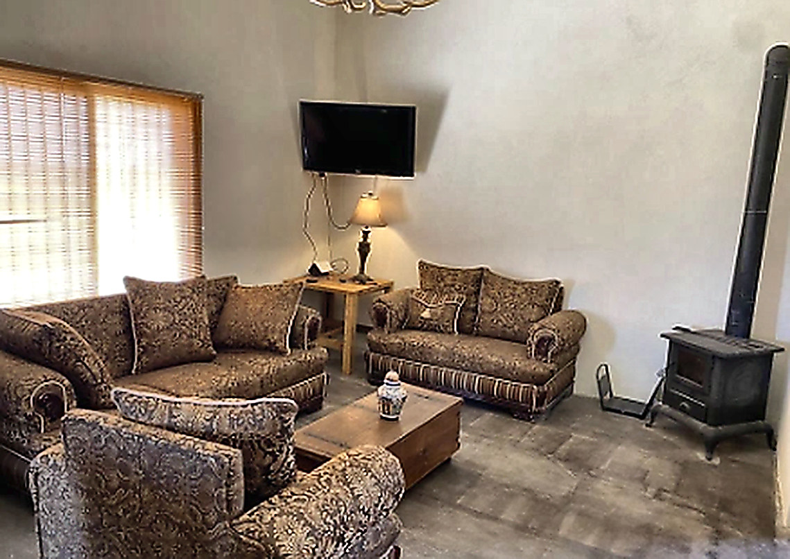 Living room with wood stove and armchairs at the Sonora ranch lodge