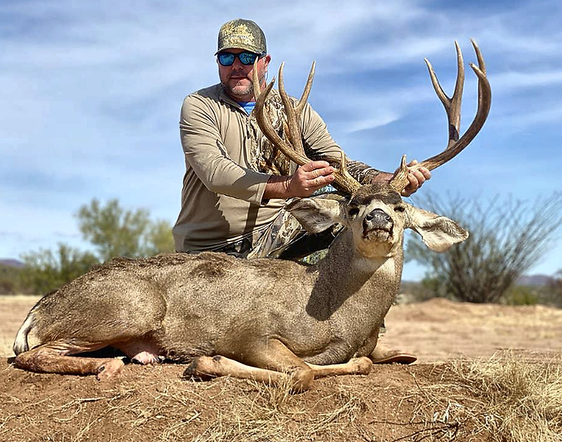 Hunter with a heavy-antlered Sonora desert mule deer buck