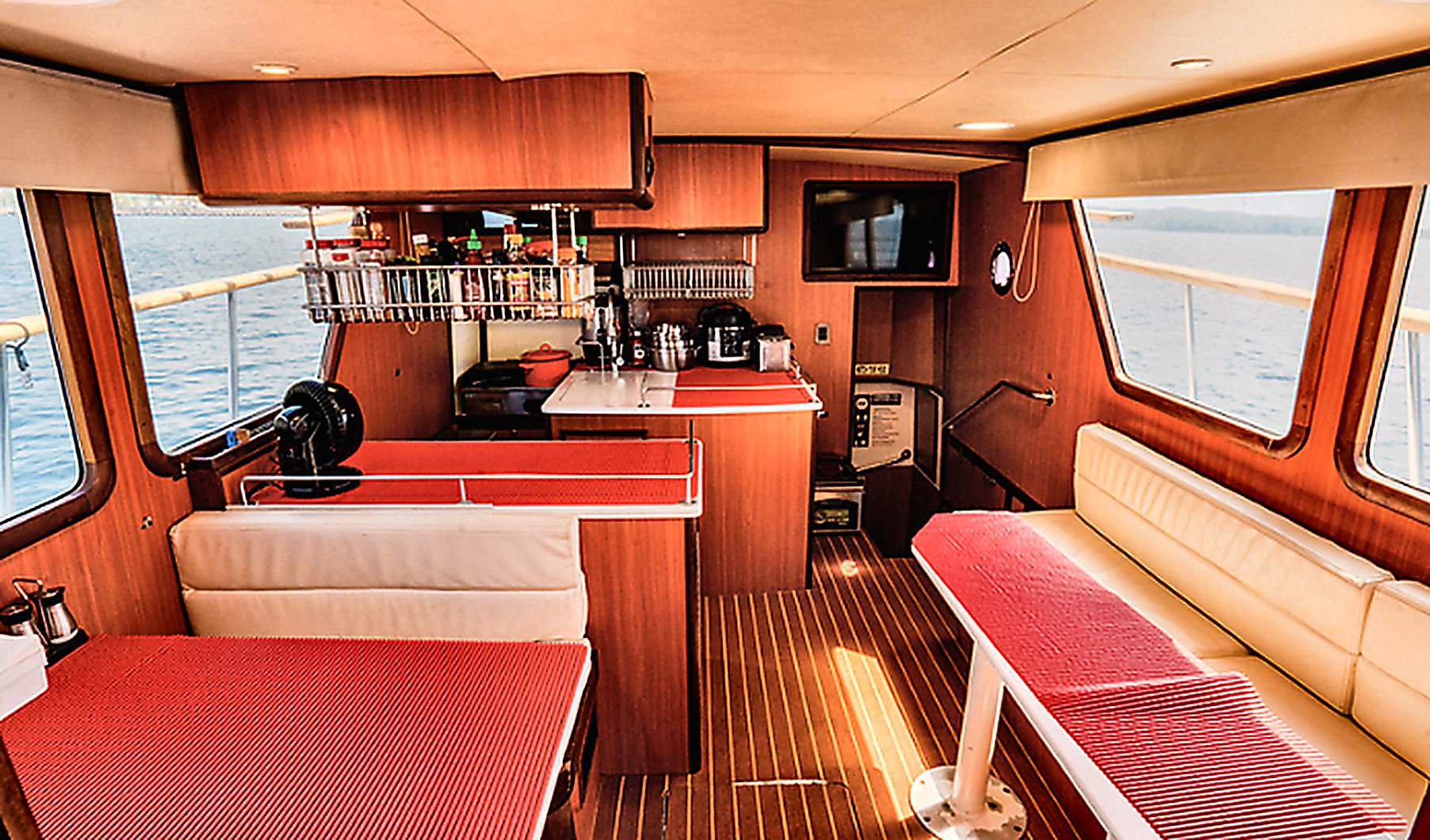 Teak-trimmed salon and galley where chef-prepared meals are served offshore